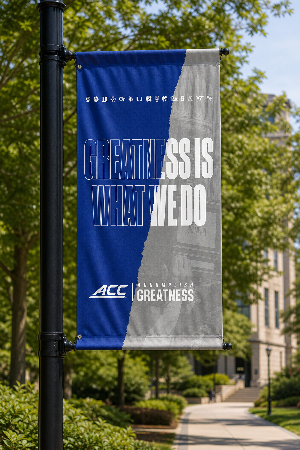 ACC Accomplish Greatness campaign displayed on a banner along a leafy college campus walkway